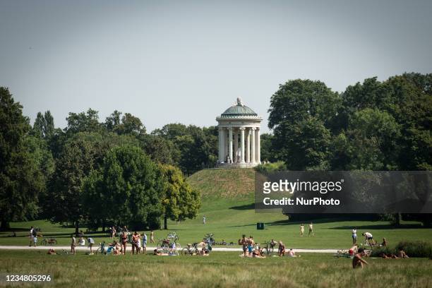 People relaxing in the grass doing sports at the Munich's Englischer Garten in Munich, Germany, on August 15, 2021. It is the city's green lung, a...