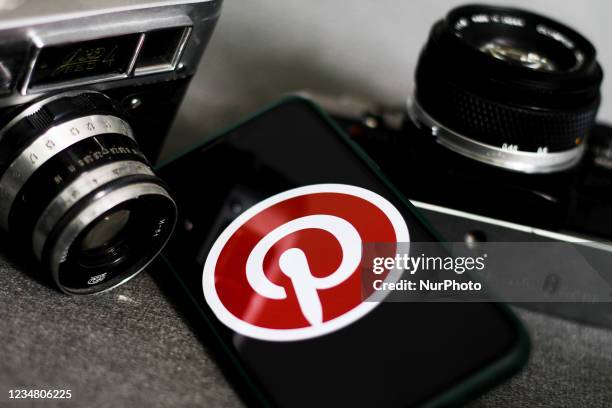 Pinterest logo displayed on a phone screen and old cameras are seen in this illustration photo taken in Krakow, Poland on August 21, 2021.