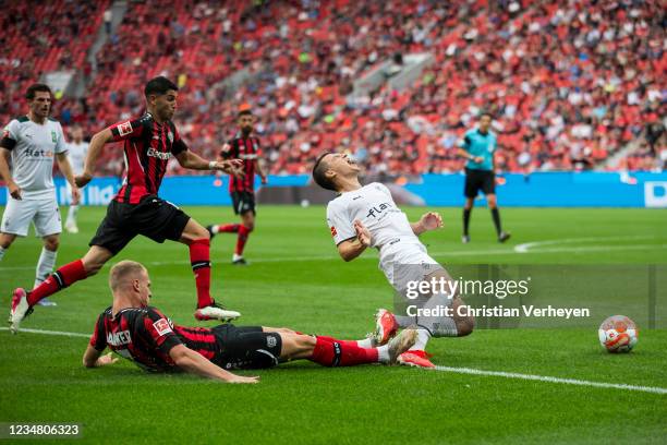 Stefan Lainer of Borussia Moenchengladbach is fouled by Mitchel Bakker of Leverkusen during the Bundesliga match between Bayer 04 Leverkusen and...