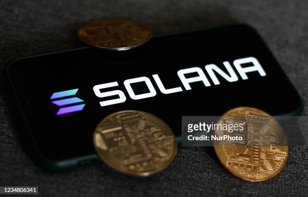 Solana logo displayed on a phone screen and representation of cryptocurrencies are seen in this illustration photo taken in Krakow, Poland on August...