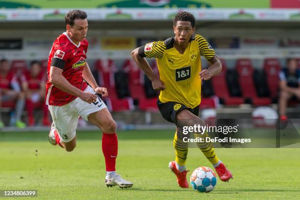 Nicolas Hoefler of SC Freiburg and Jude Bellingham of Borussia Dortmund battle for the ball during the Bundesliga match between Sport-Club Freiburg...