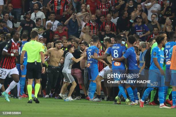 Fans invade the pitch during the French L1 football match between OGC Nice and Olympique de Marseille at the Allianz Riviera stadium in Nice,...