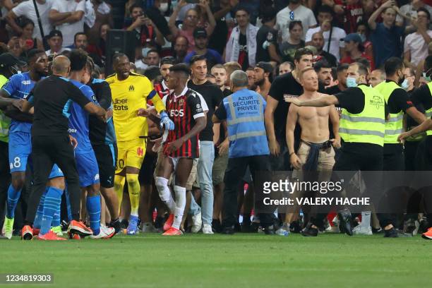 Fans try to invade the pitch during the French L1 football match between OGC Nice and Olympique de Marseille at the Allianz Riviera stadium in Nice,...