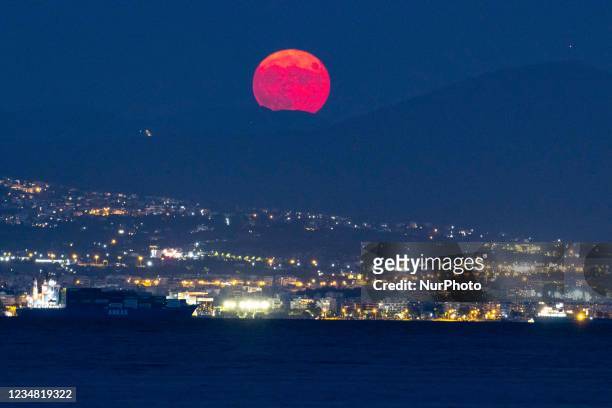 The August Sturgeon full moon rises behind the Hortiatis mountain and Thessaloniki city over the sea, skywatchers call it Blue Moon. The lunar...
