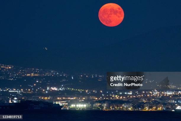 The August Sturgeon full moon rises behind the Hortiatis mountain and Thessaloniki city over the sea, skywatchers call it Blue Moon. The lunar...