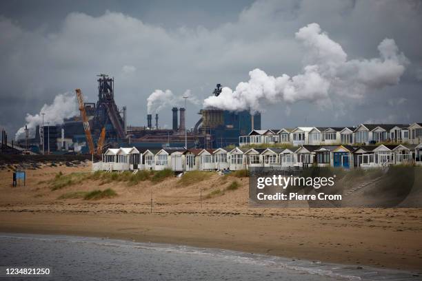 People enjoy the beach of Ijmuiden near the Tata Steel plant on August 22, 2021 in Ijmuiden. The Tata steel plant is under investigation by the Dutch...