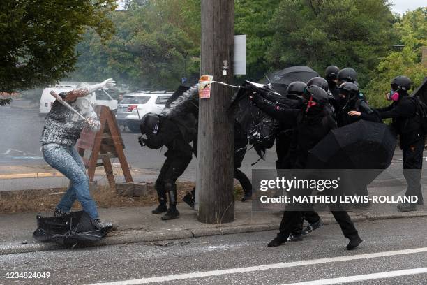 Proud Boys member "Tiny" Toese holds a bat while being sprayed with a substance by antifascist activists during an altercation between the opposing...