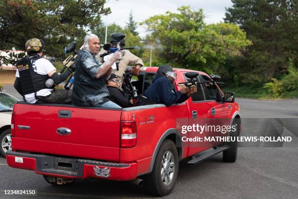 Members of the Proud Boys shoot paintballs out of the back of a truck during an altercation with anti-fascist activists following a far-right rally...