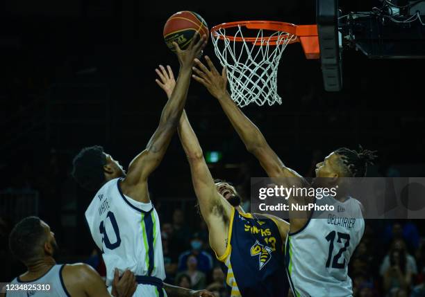 Edmonton Stingers' Brady Skeens challenged by Niagara River Lions' Tyree White and Javin Delaurier during the final of the Canadian Elite Basketball...