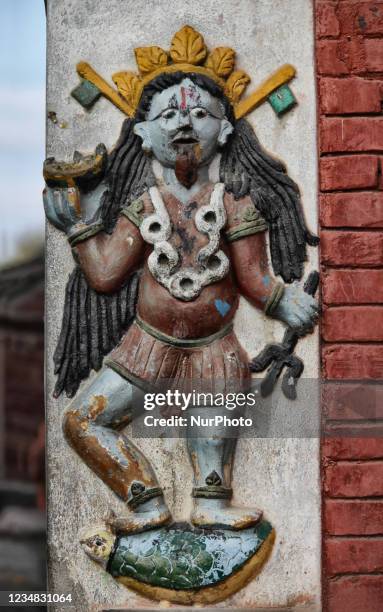 Relief figure of a female Tanatic demon with a garland of buffalo intestines around her neck at the entrance of a temple dedicated to the Goddess...