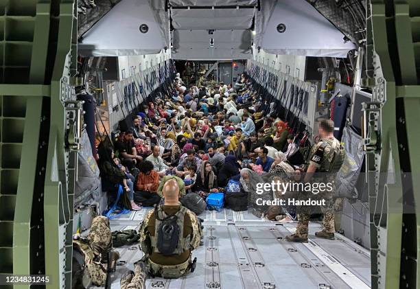 In this handout image provided by the Bundeswehr, evacuees from Kabul sit inside a military aircraft as they arrive at Tashkent Airport on August 22,...