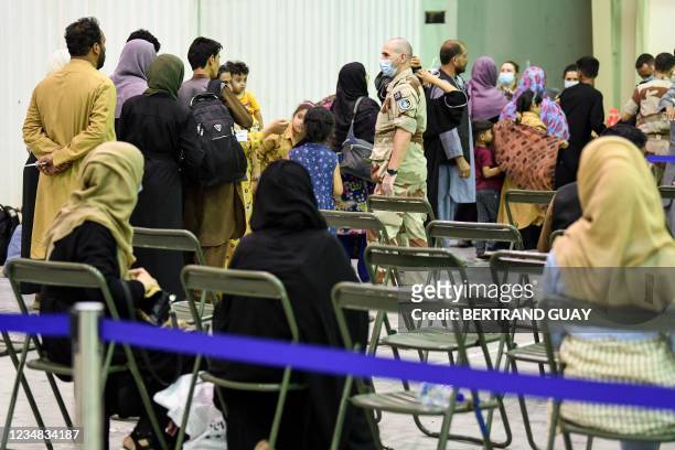 French soldier gestures as people wait in a reunion and evacuation center at the French military air base 104 of Al Dhafra, near Abu Dhabi, on August...