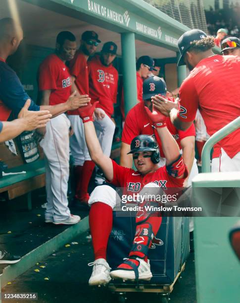 Hunter Renfroe of the Boston Red Sox gets congratulated while riding in a laundry cart through the dugout after his home run against the Texas...