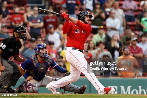 As catcher Jose Trevino of the Texas Rangers looks on, Travis Shaw of the Boston Red Sox follows through on his game winning grand slam during the...