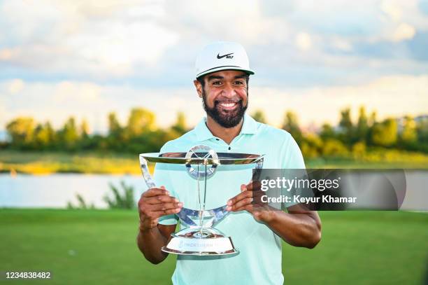 Tony Finau smiles with the tournament trophy following his playoff victory during the final round of THE NORTHERN TRUST, the first event of the...