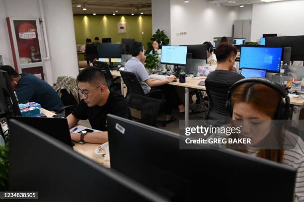 This photo taken on July 5, 2021 shows staff working on computers at the Beijing office of XiaoIce, a cutting-edge artificial intelligence system...