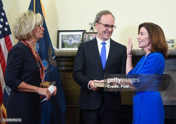 Kathy Hochul is administered the oath of office as New York State governor by Court of Appeals Chief Judge Janet DiFiore on a Bible held by her...