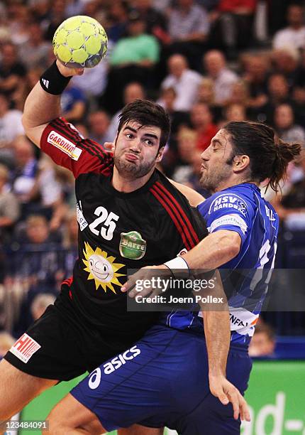 Daniel Svensson of Luebbecke is challenged by Bertrand Gille of Hamburg during the Toyota Handball Bundesliga match between HSV Hamburg and TuS...