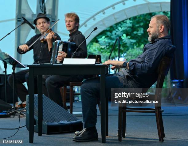 August 2021, Brandenburg, Neuhardenberg: Samuel Finzi , actor and the Glücklich brothers with Valentin Butt on accordion and Roland Satterwhite on...