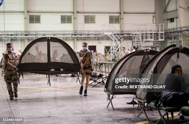 French soldiers set up tents at the refugee reception centre as part of the operation "Apagan" at the French military air base 104 of Al Dhafra, near...