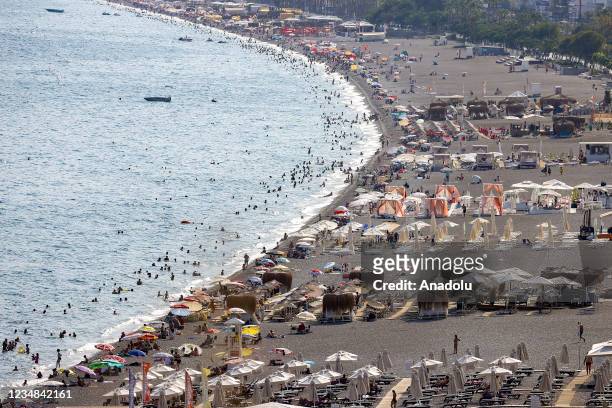 Drone photo shows people enjoy the sunny day at a beach in Antalya, Turkey on August 24, 2021. Number of tourists coming to Antalya has approached 5...