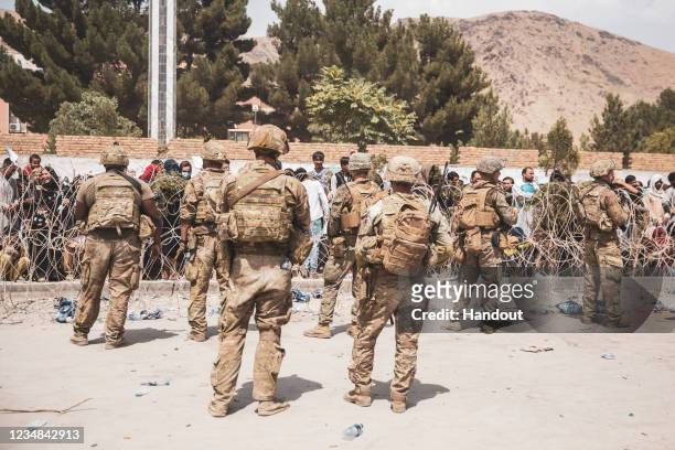 This handout image shows U.S. Soldiers and Marines assist with security at an Evacuation Control Checkpoint during an evacuation at Hamid Karzai...