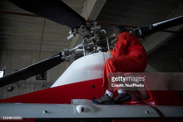 Firefight engineer inspect an AB412 helicopter before flight in Lamezia Terme , Italy, on August 23, 2021. The flight department of the fire brigade...