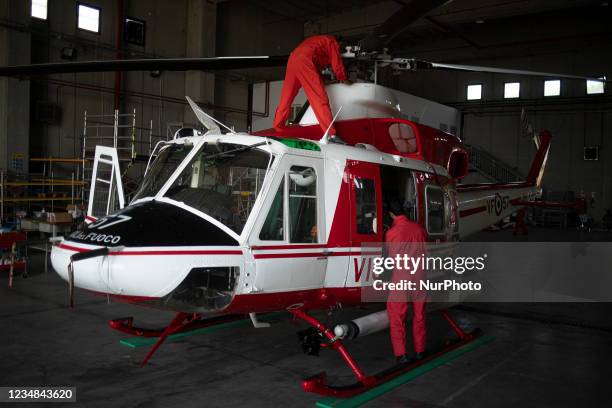 Firefight engineers inspect an AB412 helicopter before flight in Lamezia Terme , Italy, on August 23, 2021. The flight department of the fire brigade...