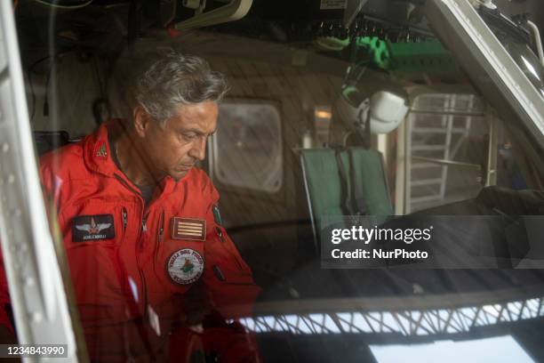 An on-board firefighter engineer inspecting the AB412 helicopter before a flight in Lamezia Terme , Italy, on August 23, 2021. The flight department...