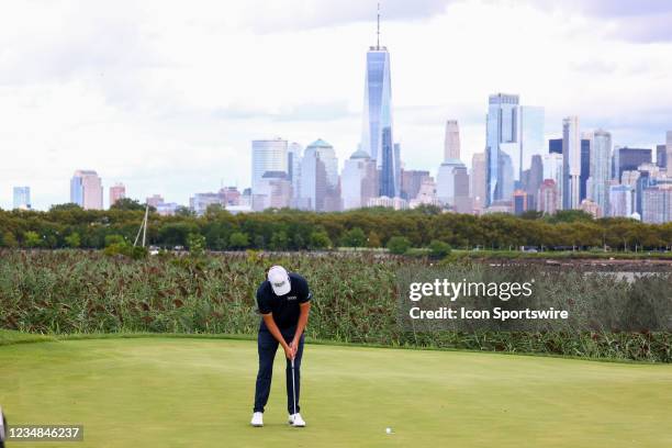 Patrick Cantlay of the United States putts on the 14th green with the New York Skyline behind him during the final round of the Northern Trust golf...