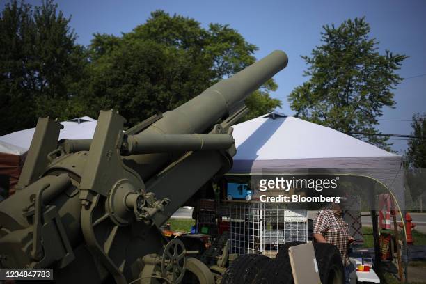 Shopper browses a vendor's tent next to a howitzer artillery piece during the U.S. 127 yard sale in West Manchester, Ohio, U.S., on Sunday, Aug. 8,...