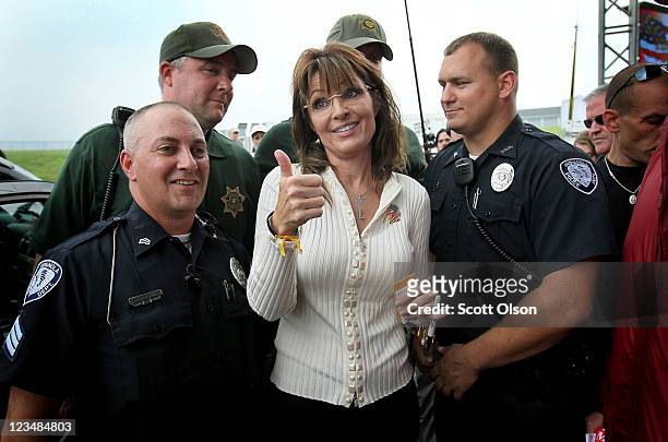 Former Alaska Governor Sarah Palin poses for a picture with police officers who were providing security during the Tea Party of America's "Restoring...