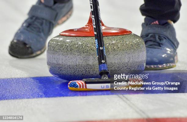 Curler sweeps in front of a stone for Team USA at practice for the Curling Night in America competition at the Great Park Ice & Five Point Arena in...