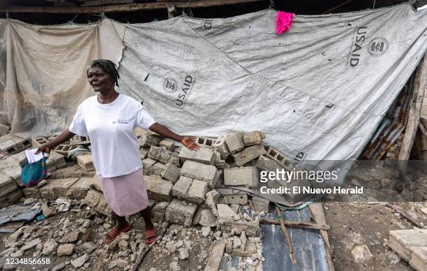 Mertilia Zamor is using tarps she used for shelter after Hurricane Matthew to protect herself for the elements after the eartquake knocked down the...