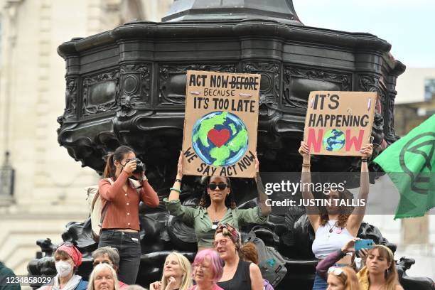 Climate activists from the Extinction Rebellion group gather at Piccadilly Circus in central London on August 25, 2021 to demonstrate during the...