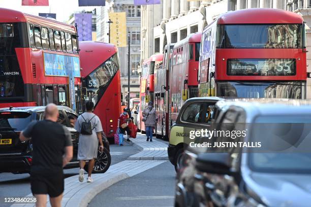 Buses and cars are stuck in a traffic jam on Oxford Street as climate activists from the Extinction Rebellion group block Oxford Circus in central...