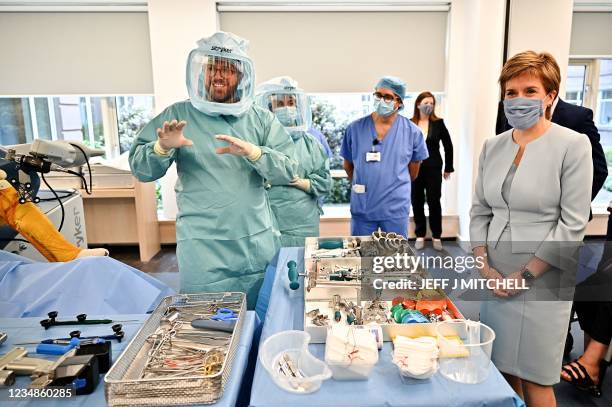 Scotland's First Minister Nicola Sturgeon gestures as she tours a mock theatre set up with innovative new medical equipment, including robotic...