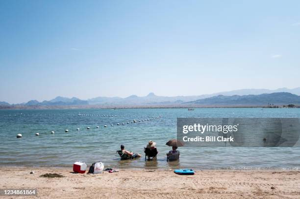 Beachgoers cool off in the waters of Lake Havasu, fed by the Colorado River, at the Rotary Community Park in Lake Havasu City, Ariz., on Tuesday,...