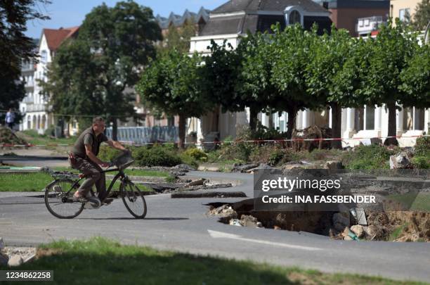 Man rides his bicycle on streets destroyed by the flood in Bad Neuenahr, western Germany on August 25 weeks after heavy rain and floods caused major...