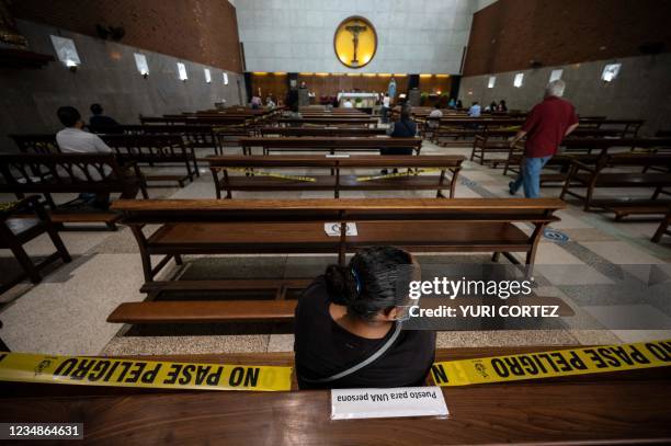Catholic woman attends a mass keeping physical distance and wearing a mask against the spread of COVID-19 in the parish of El Buen Pastor in the...