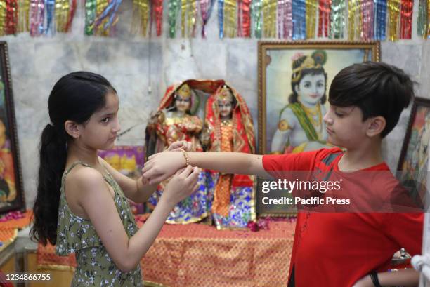 Pakistani girl tying Rakhi on the wrist of her brother on the occasion of Hindu Festival Raksha Bandhan at Shri Krishna Mandir Ravi road in...