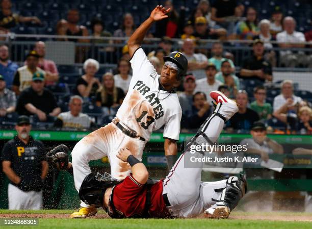 Ke'Bryan Hayes of the Pittsburgh Pirates scores on a sacrifice fly in the fourth inning against Daulton Varsho of the Arizona Diamondbacks during the...