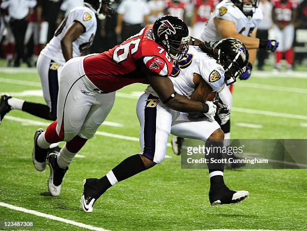 Damien Berry of the Baltimore Ravens carries the ball against Kiante Tripp of the Atlanta Falcons during a preseason game at the Georgia Dome on...