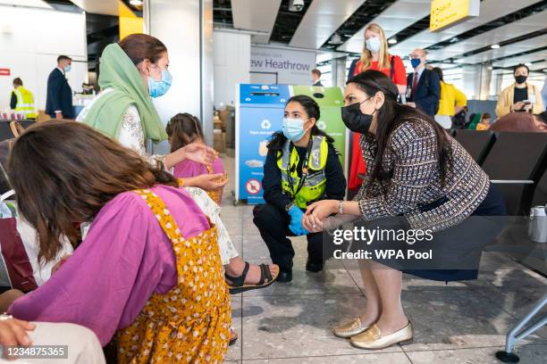 Home Secretary Priti Patel talking to Malalai Hussiny a refugee from Afghanistan who arrived on a evacuation flight at Heathrow Airport on August 26,...