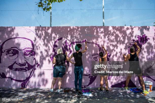 Members of UNLOGIC artistic group repainting a feminist mural that appeared vandalized during the past International Women's Day. The mural...