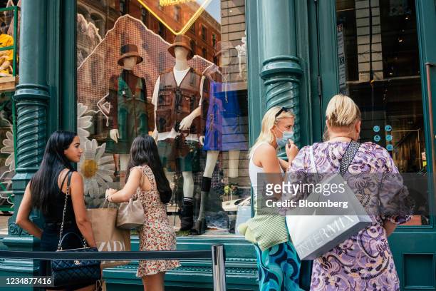 Shoppers wait in line to enter a Prada store in the SoHo neighborhood of New York, U.S., on Wednesday, Aug. 25, 2021. Consumer spending in the second...
