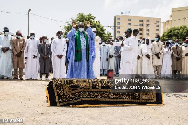 Relatives together with Chadian and Senegalese mourners look on as an Imam says a prayer over the coffin of late ex-Chadian President Hissene Habre...