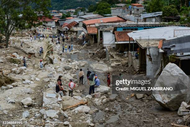 Residents are seen in an area where several homes were destroyed by a mudslide caused by heavy rains in Valle del Mocoties community, municipality of...