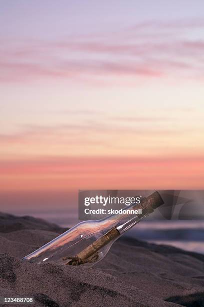 nachricht in einer flasche im sonnenuntergang - flaschenpost stock-fotos und bilder