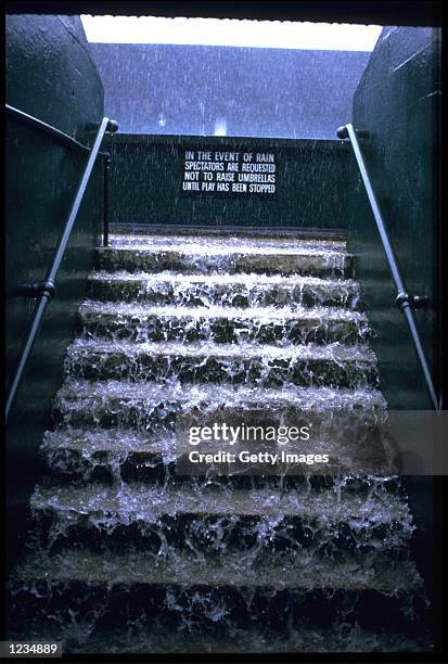 A TORRENTIAL DOWNPOUR ON THE CENTRE COURT AT WIMBLEDON STOPS PLAY.